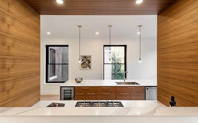 A kitchen with wooden cabinets and a stove top oven.