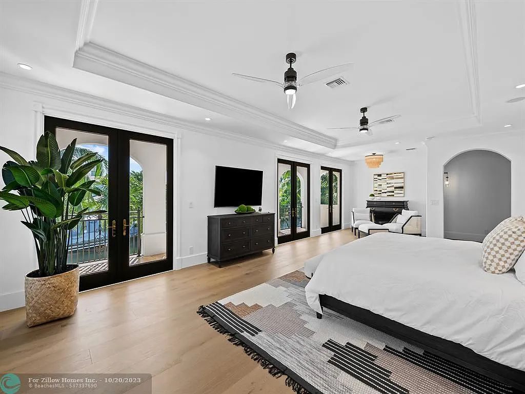 A large bedroom with a bed , television , and sliding glass doors.