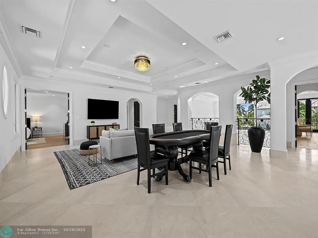 A living room with a table and chairs and a television.