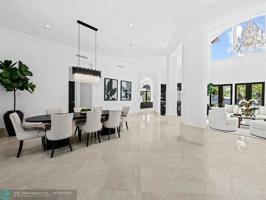 A large dining room with a table and chairs and a chandelier.