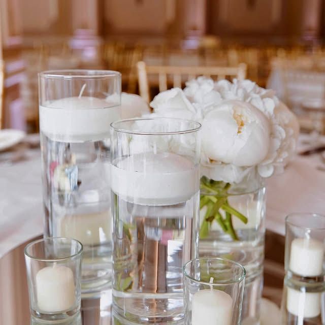 A table with a vase of flowers and candles on it