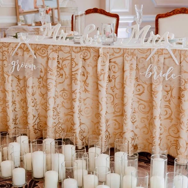 A table with candles and signs for the bride and groom