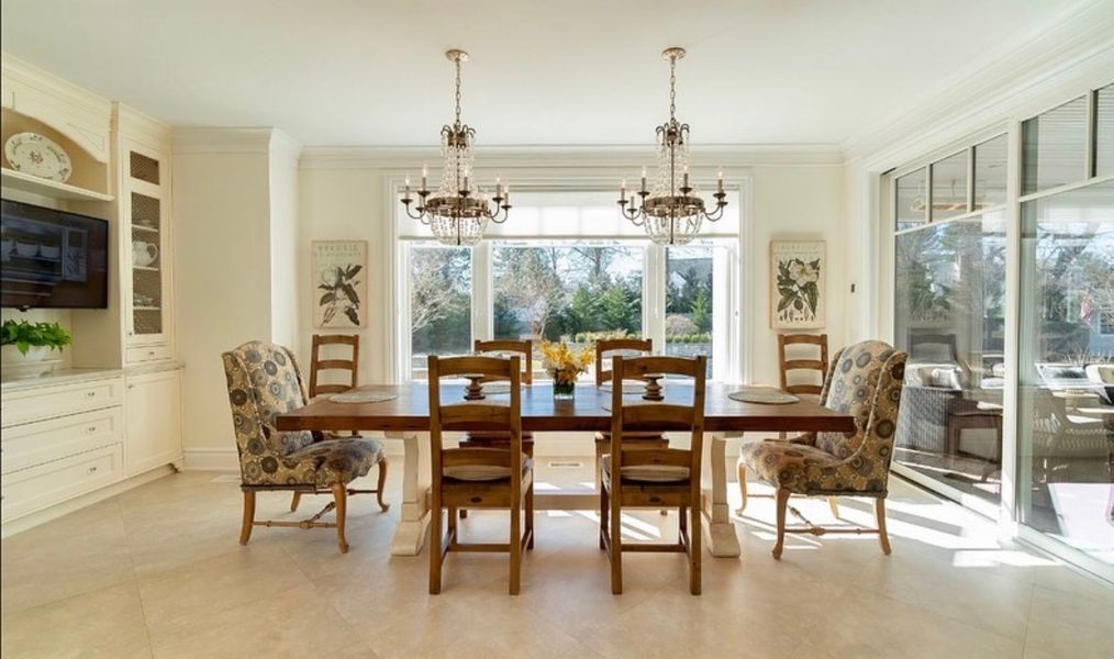 A dining room with a table and chairs and a large window