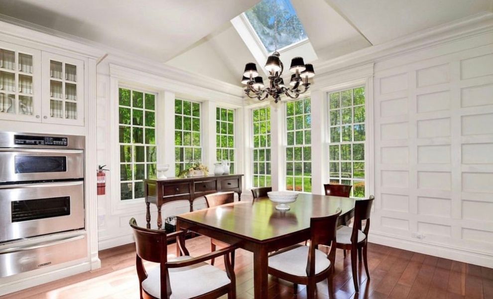 A dining room with a table and chairs and a skylight