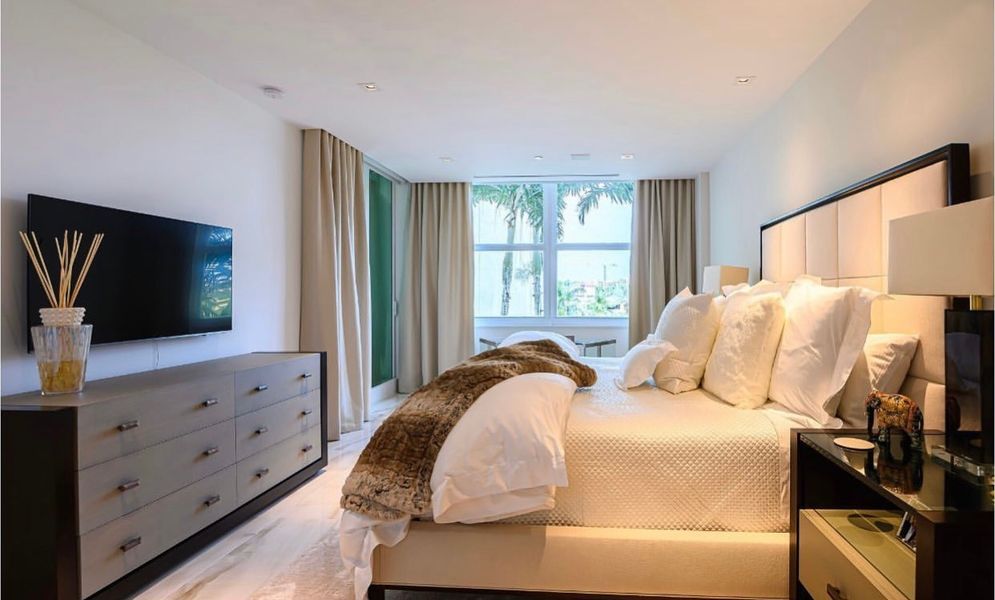 A bedroom with a large bed and a flat screen tv