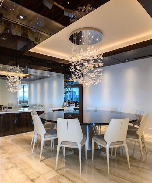 A dining room with a round table and white chairs