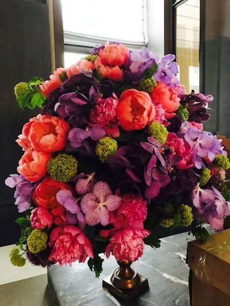 A vase filled with pink and purple flowers sits on a table