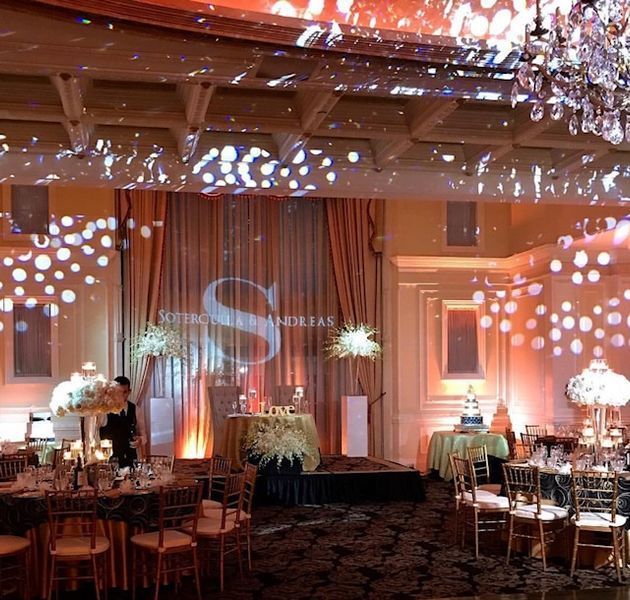 A large room with tables and chairs and a projection of the letter s on the wall