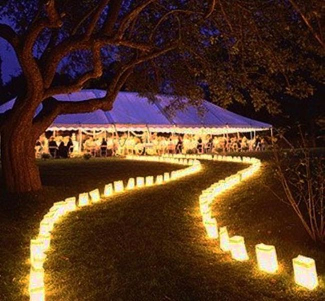 A row of candles are lit up in front of a tent