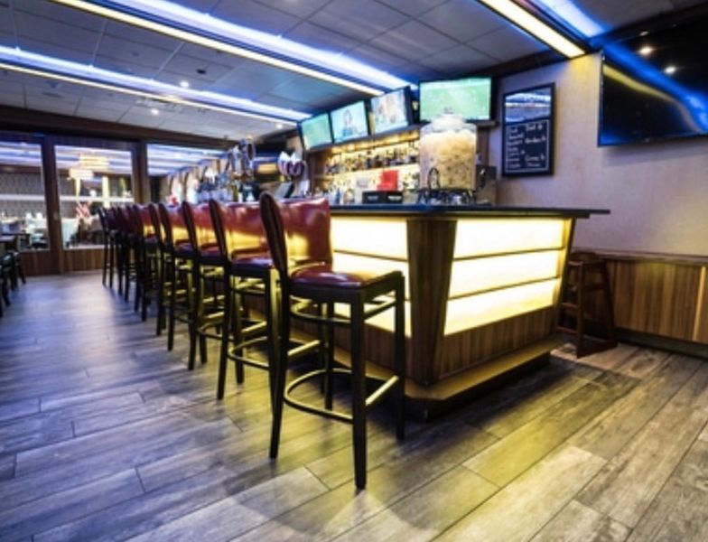 A bar in a restaurant with a lot of stools