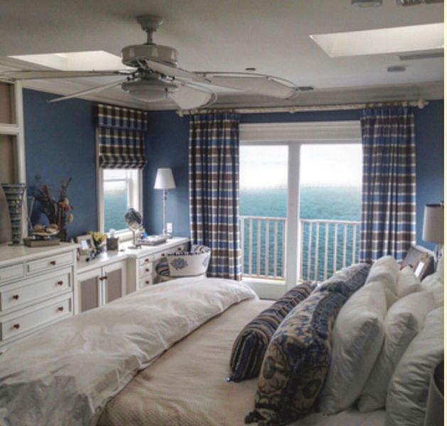 A bedroom with a large bed and a ceiling fan