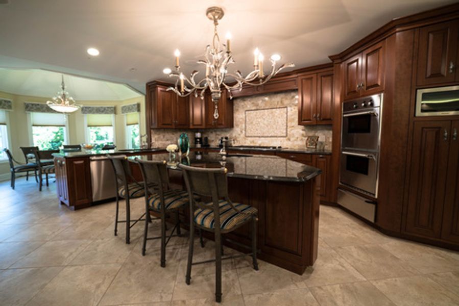 A kitchen with a large island and a chandelier hanging from the ceiling