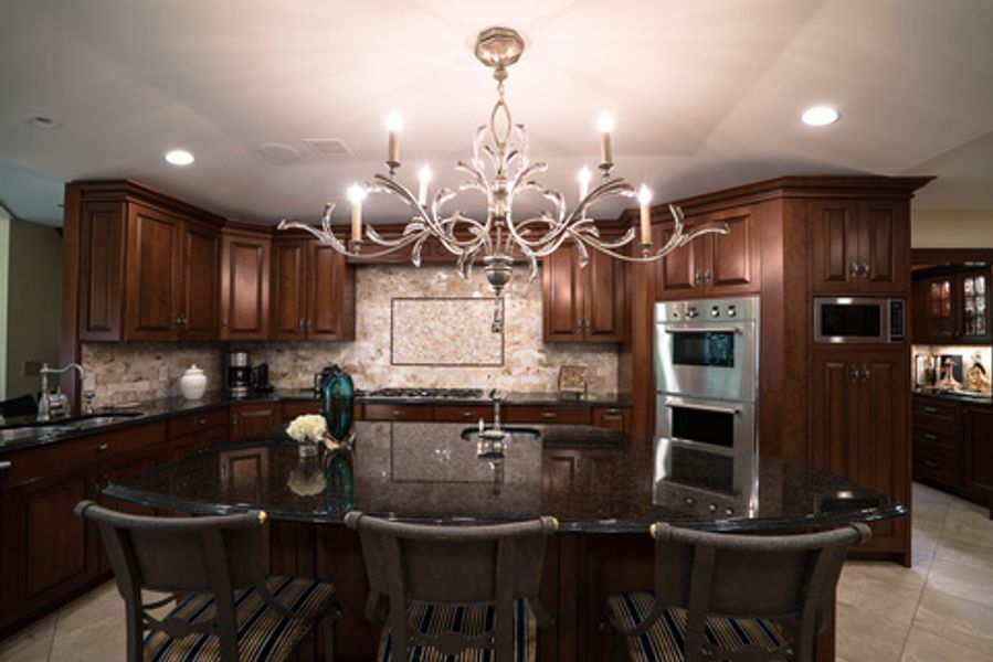 A kitchen with a large island and a chandelier hanging from the ceiling