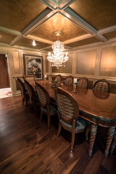 A dining room with a long table and chairs and a chandelier