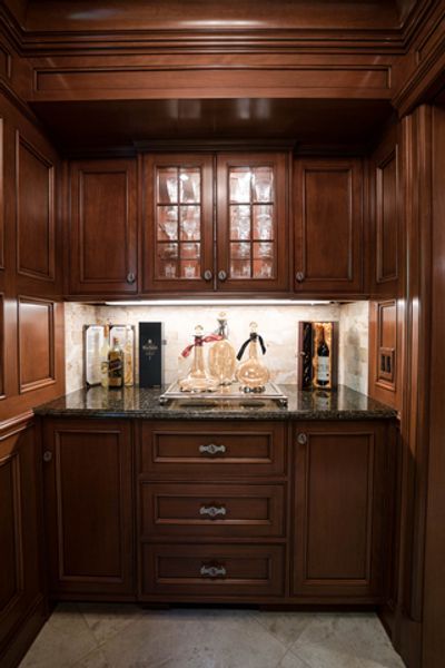 A kitchen with wooden cabinets and a black counter top