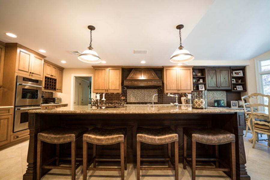 A kitchen with a large island and stools in it