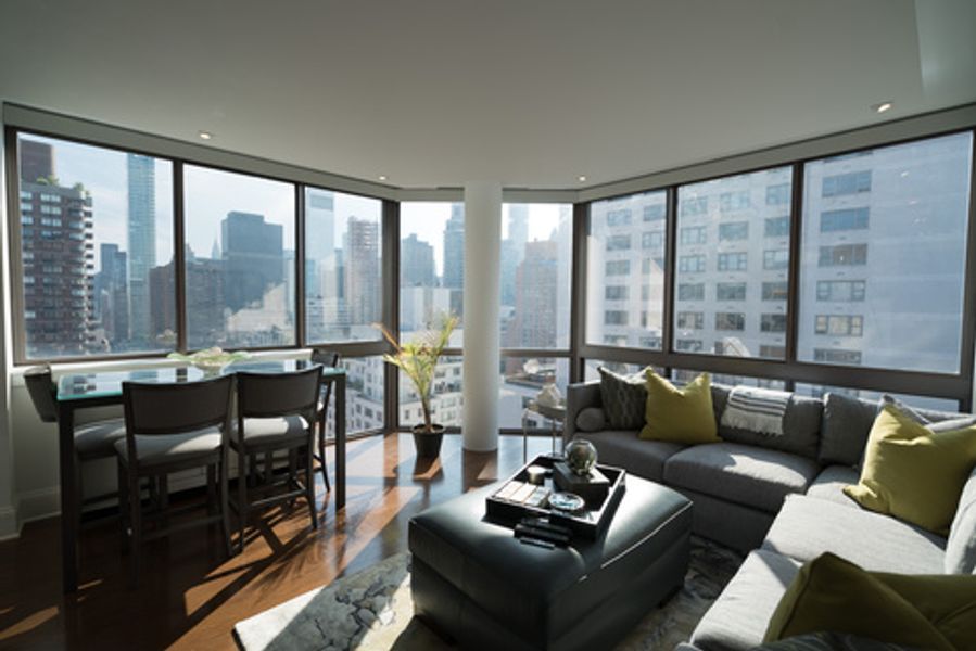 A living room with a couch and a table with a view of the city
