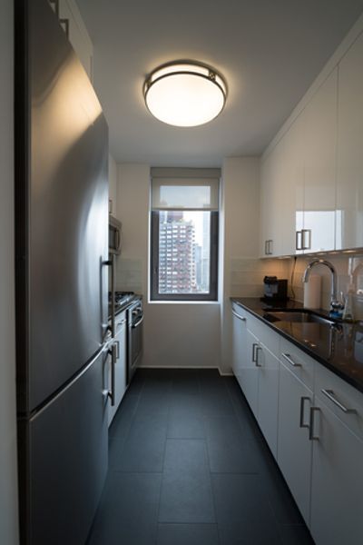 A kitchen with stainless steel appliances and white cabinets