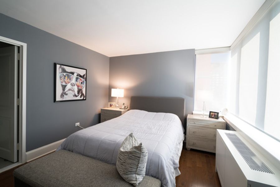 A bedroom with a large bed and a picture on the wall