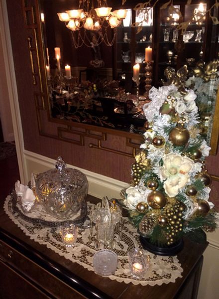 A small christmas tree is sitting on a table in front of a mirror
