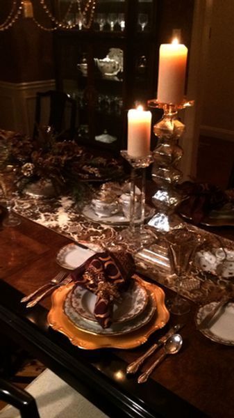 A dining room table with plates and candles on it