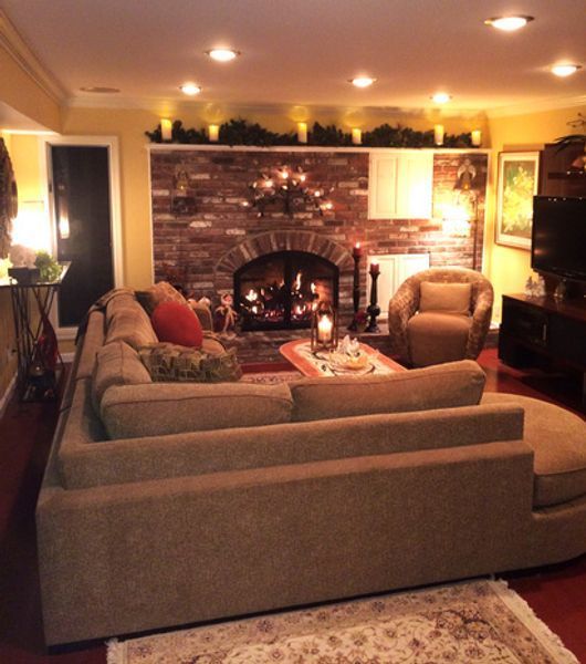 A living room with a large sectional couch and a fireplace