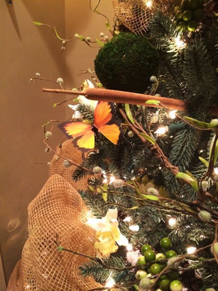 A close up of a christmas tree with a butterfly on it