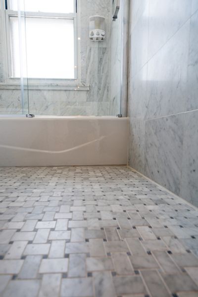 A bathroom with a bathtub and a tiled floor