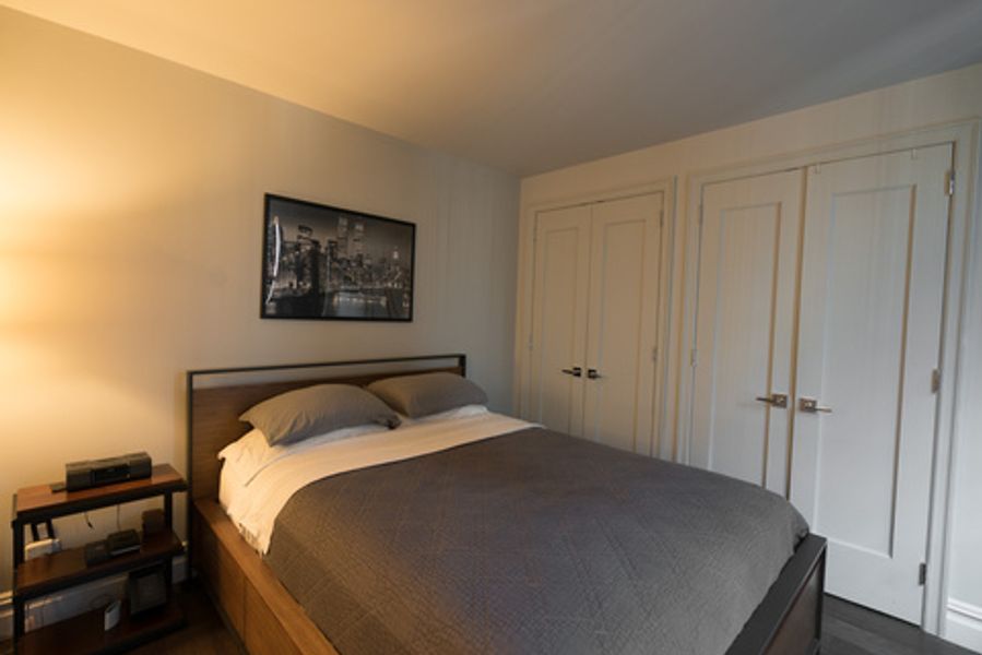 A bedroom with a bed and a picture on the wall