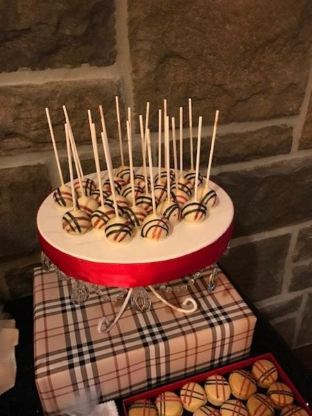 A bunch of cake pops sitting on top of a cake stand