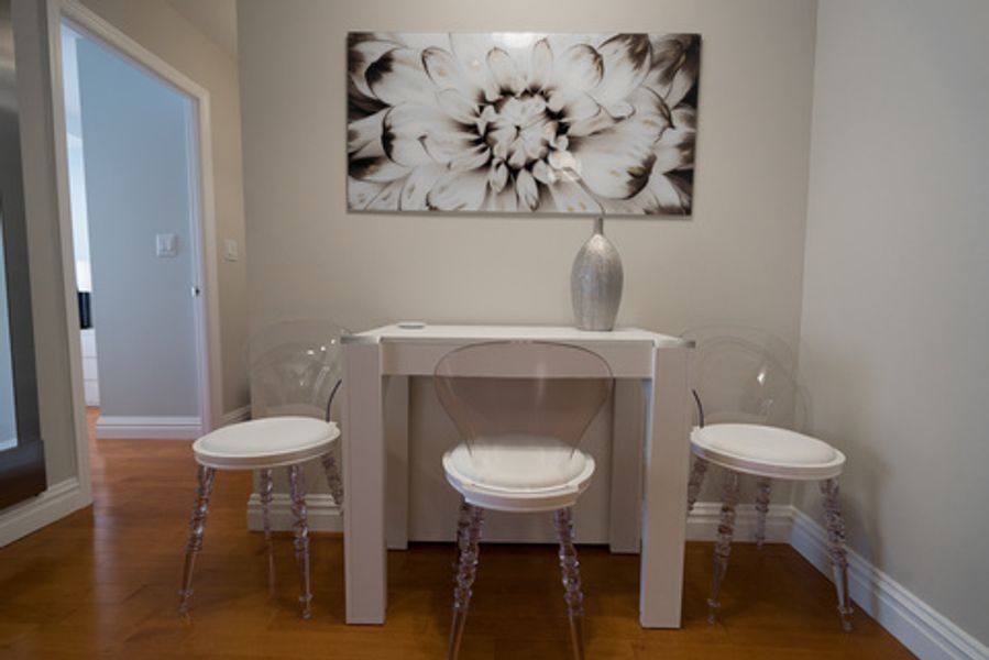 A room with a table and chairs and a painting on the wall