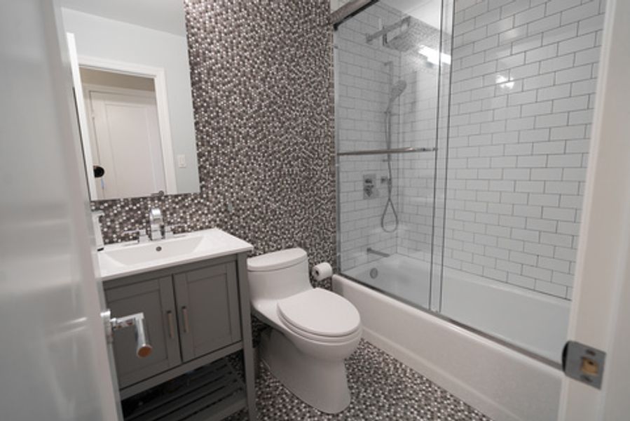 A bathroom with a toilet, sink, shower and bathtub