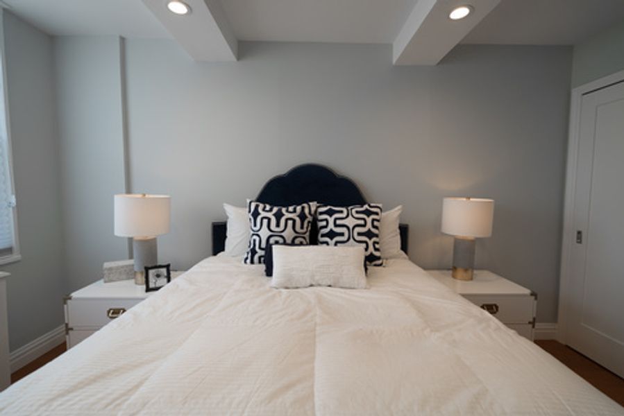 A bedroom with a large bed and two lamps