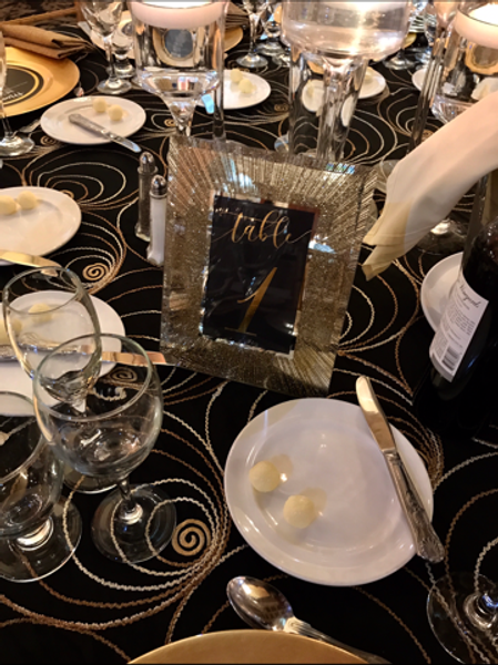 A table with plates glasses and a sign that says tails