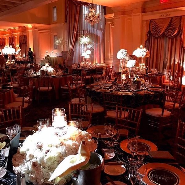 A large room with tables and chairs set up for a wedding reception