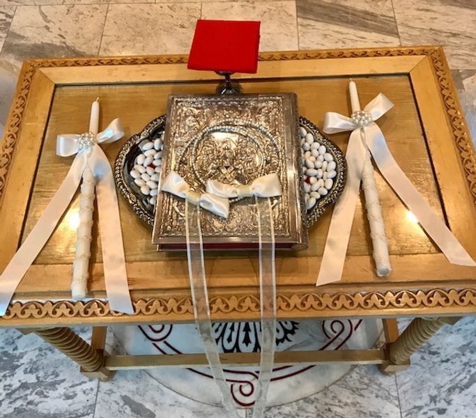 A wooden table with a bible and candles on it