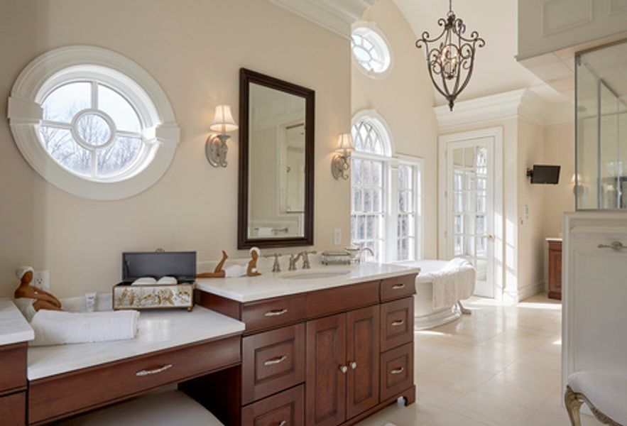 A bathroom with two sinks, a mirror and a tub