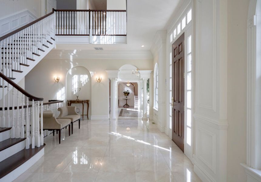 A hallway with stairs and a marble floor
