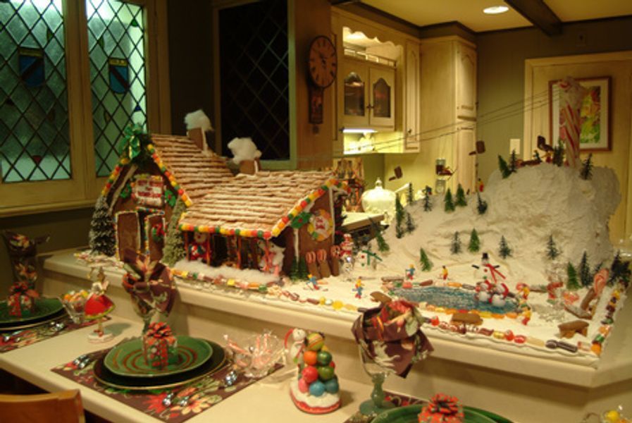 A kitchen with a gingerbread house on the counter
