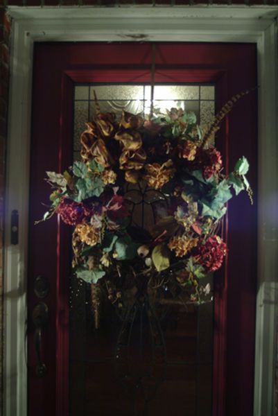A wreath is hanging on a red door