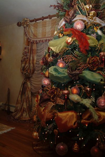 A christmas tree is sitting in a living room next to a window
