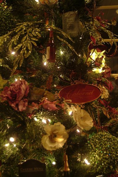 A close up of a christmas tree decorated with flowers and lights
