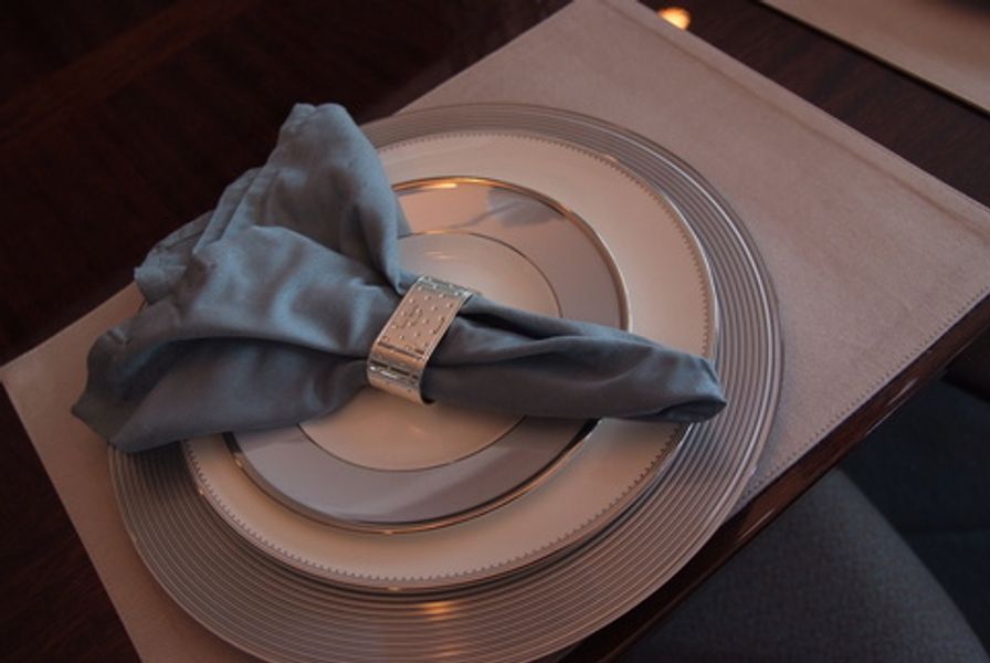 A napkin is sitting on top of a plate on a table