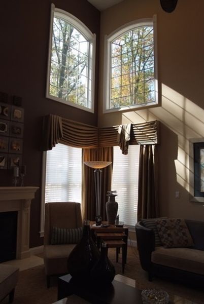 A living room with lots of windows and a fireplace