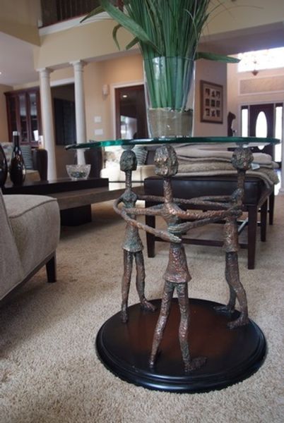 A table with a glass top and two statues on it