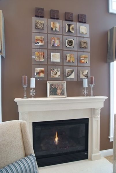A living room with a fireplace and pictures on the wall above it