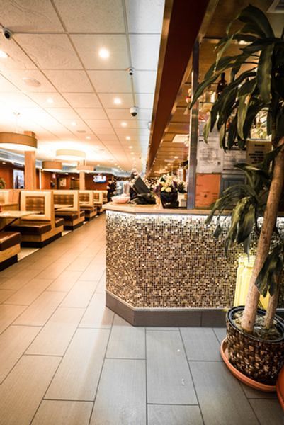The inside of a restaurant with tables and a counter