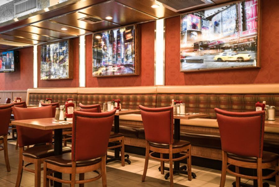 A restaurant with tables and chairs and paintings on the wall