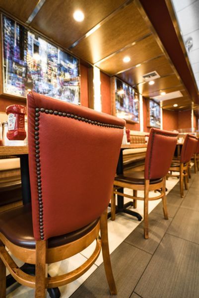 A restaurant with red chairs and tables with telephones on them