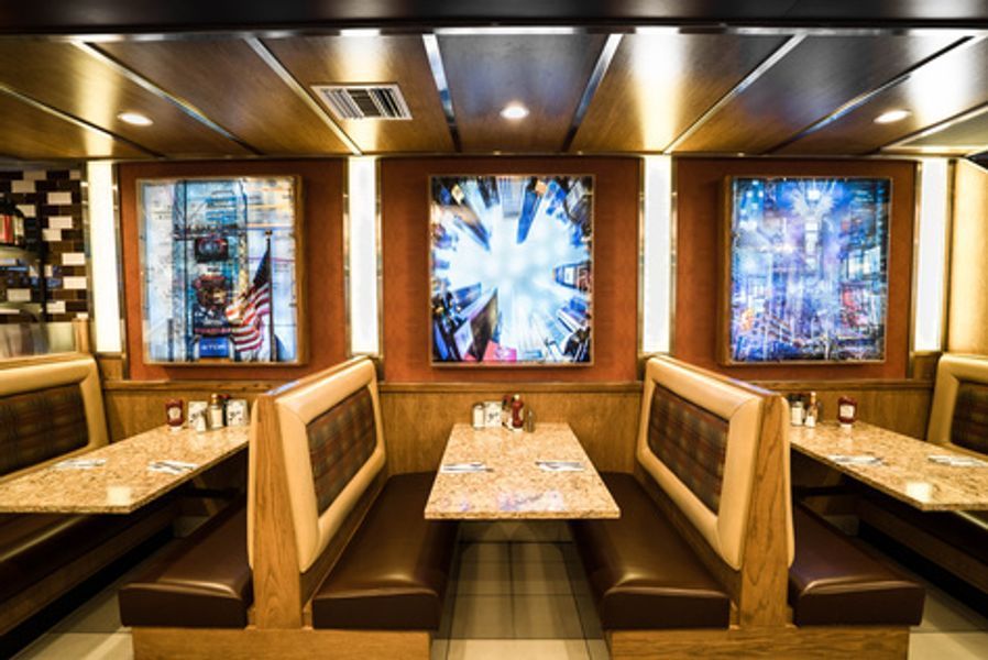 A diner with tables and booths and paintings on the walls